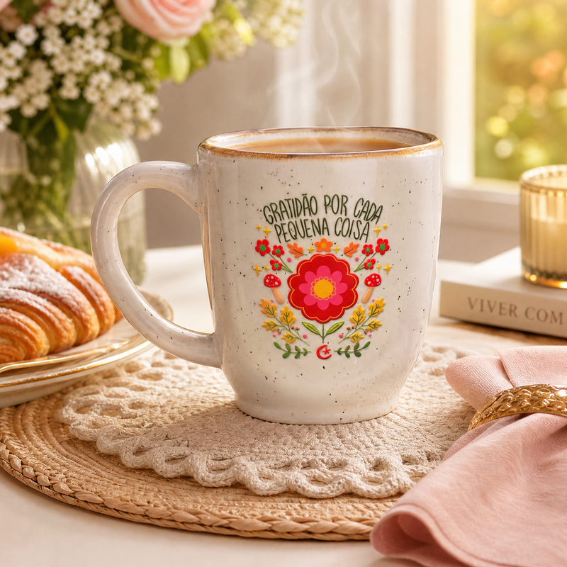 caneca de ceramica escrita graditão por cada pequena coisa com flores em uma mesa de cafe 